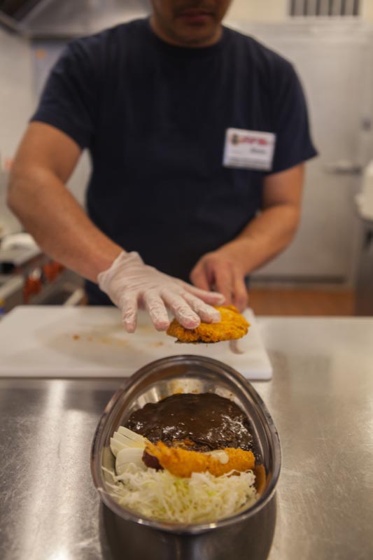 Go! Go! Curry! employee plating a home run Japanese katsu curry combo in a shining kitchen. Only the best ingredients