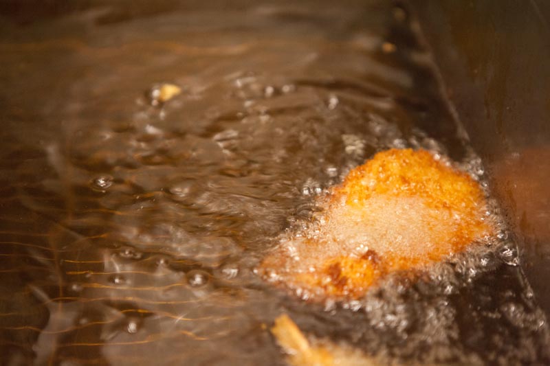 A katsu cutlet gets deep fried in a fryer. Deep Fry